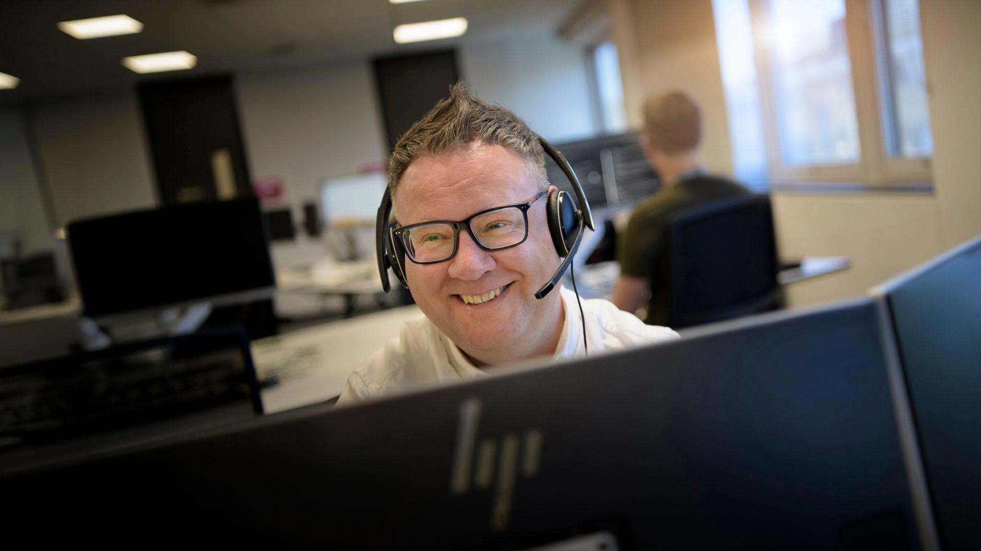 A man with headphones on smiling.