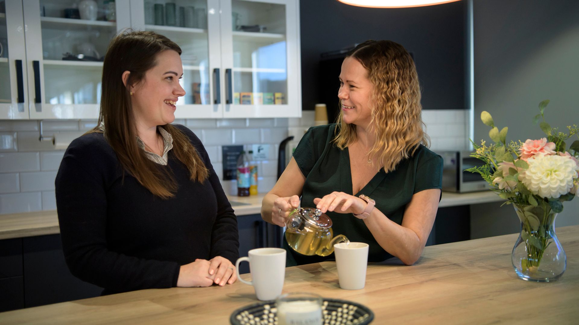 Two women pouring tea.