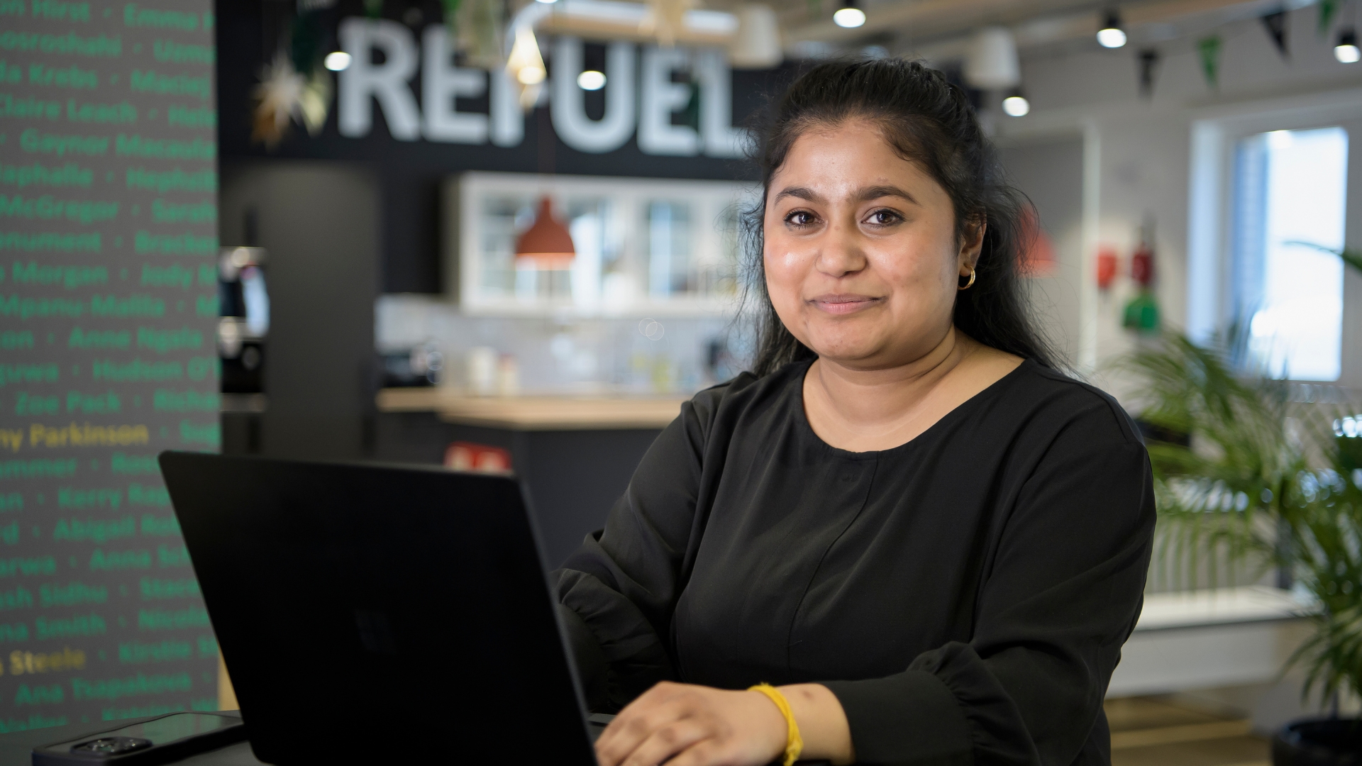 A professional person sitting at a table using a laptop to work.