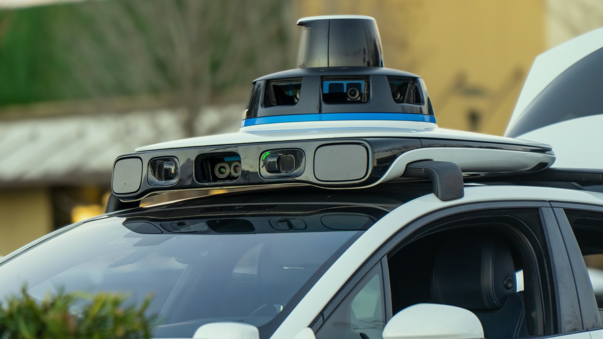 A LiDAR-equipped self-driving electric vehicle charging in a parking area.